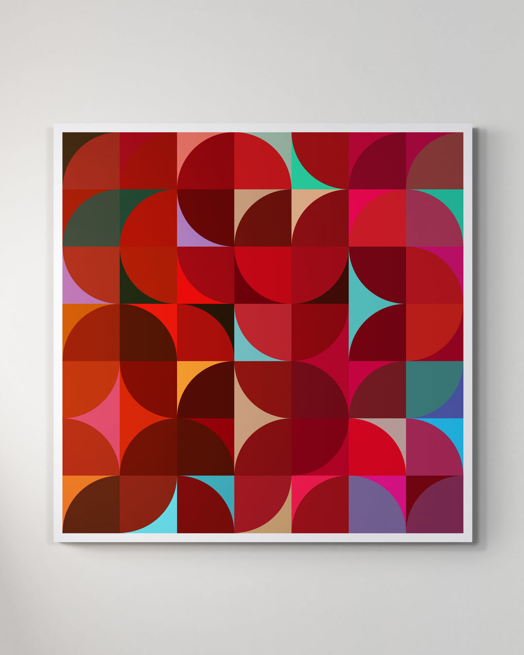 A giclée print of a colorful geometric digtal artwork on a white wall. Abstract floral pattern, mainly red and soft pastel colors